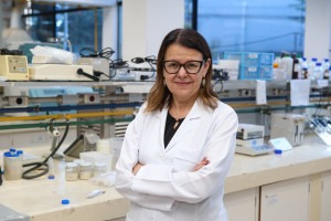 Rosiane Lopes da Cunha é uma mulher branca de cabelos castanho na altura do ombro, veste óculos e jaleco branco. Está com os braços cruzados posando para a foto destro do laboratório da FEA Unicamp onde a emulsão gel foi desenvolvida.