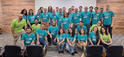 Participantes do evento de reinauguração do prédio da Incamp vestidos com camisas na cor verde Fim da descrição.