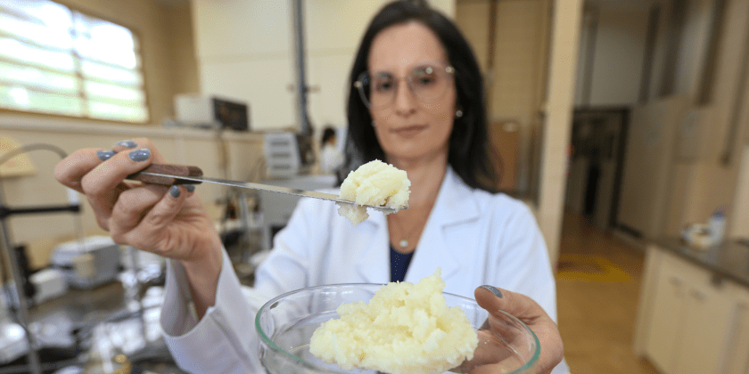 A imagem mostra a professora Ana Paula Badan, no Laboratório de Óleos e Gorduras da Unicamp, segurando a gordura obtida a partir do óleo de macaúba. Fim da descrição.