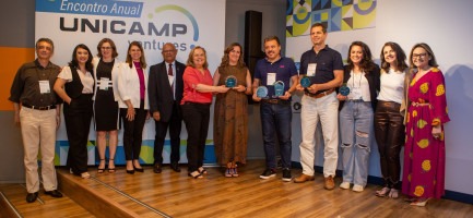 Fotografia colorida de pessoas sendo premiadas no Prêmio Empreendedor da Unicamp 2023. Todas estão em pé e posando para a foto.