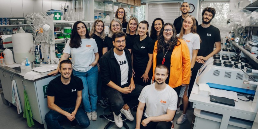 Equipe da ÄIO, composta por nove mulheres e cinco homens, dentro de laboratório da empresa. Fim da descrição