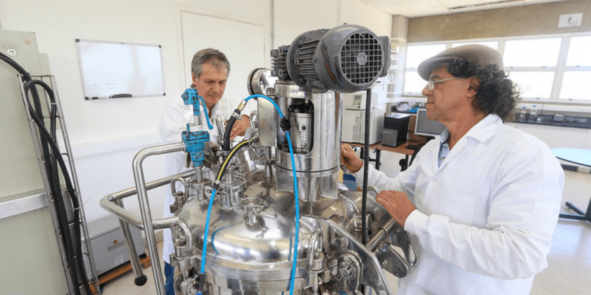 Lucídio Fardelône (em segundo plano) e Gustavo Paim Valença trabalhando no laboratório da BioAcids Fim da descrição.