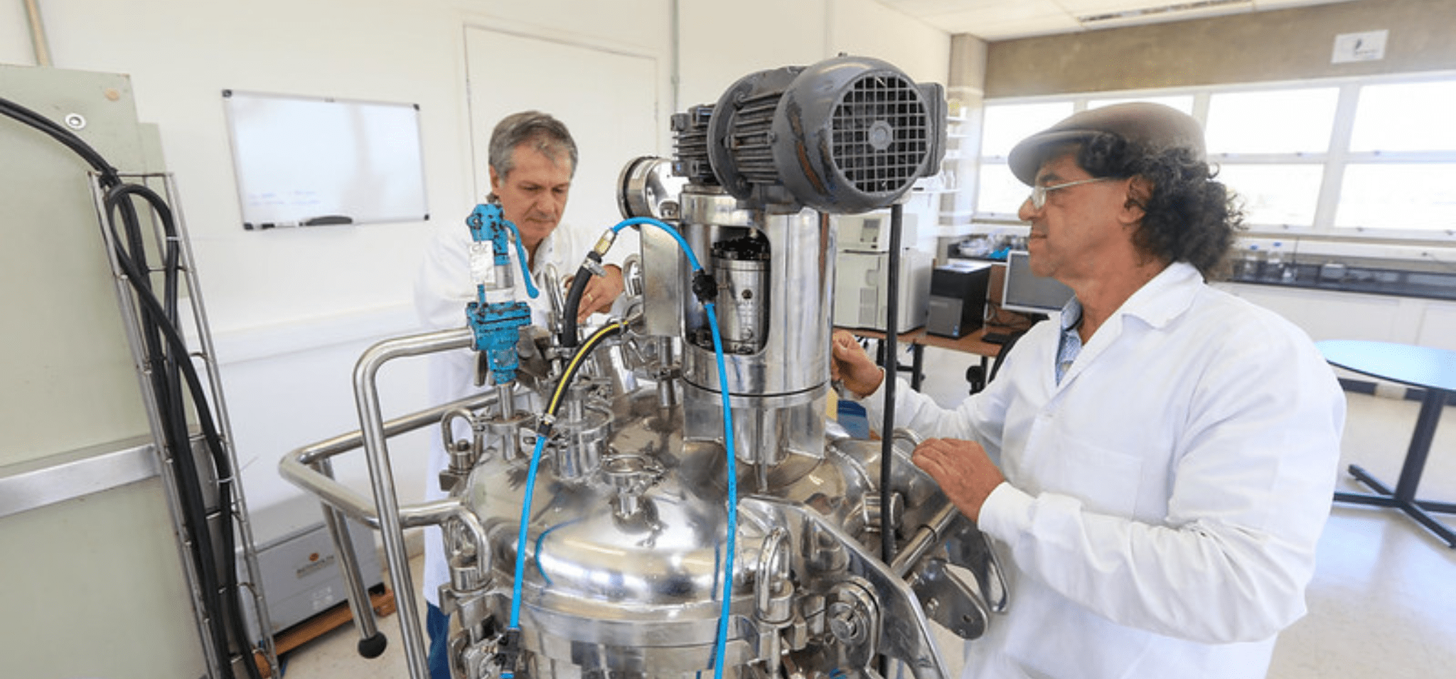 Lucídio Fardelône (em segundo plano) e Gustavo Paim Valença trabalhando no laboratório da BioAcids Fim da descrição.