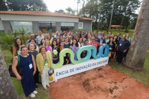 Fotografia colorida diurna de um grupo diverso de pessoas posicionado atrás do letreiro da Inova.