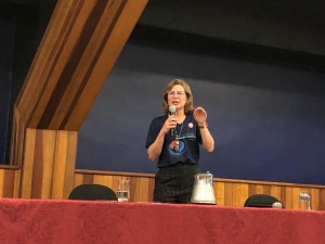 Professora Ana Maria Frattini, em pé, durante a cerimônia de abertura do Congresso de Iniciação Científica da Unicamp. Fim da descrição.