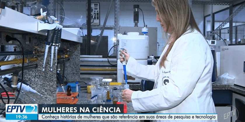 A imagem mostra uma pesquisadora mulher em seu laboratório. A imagem também contém uma legenda: Mulheres na ciência - Conheça histórias de mulheres que são referência em suas áreas de pesquisa e tecnologia. Fim da descrição.